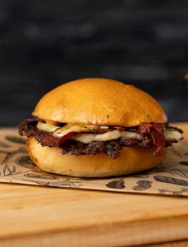 Le meilleur Smashburger est le Smash Poitrine de Big Fernand. Un burger smashé avec raclette, poitrine fumée, oignons et sauce tata cocktail